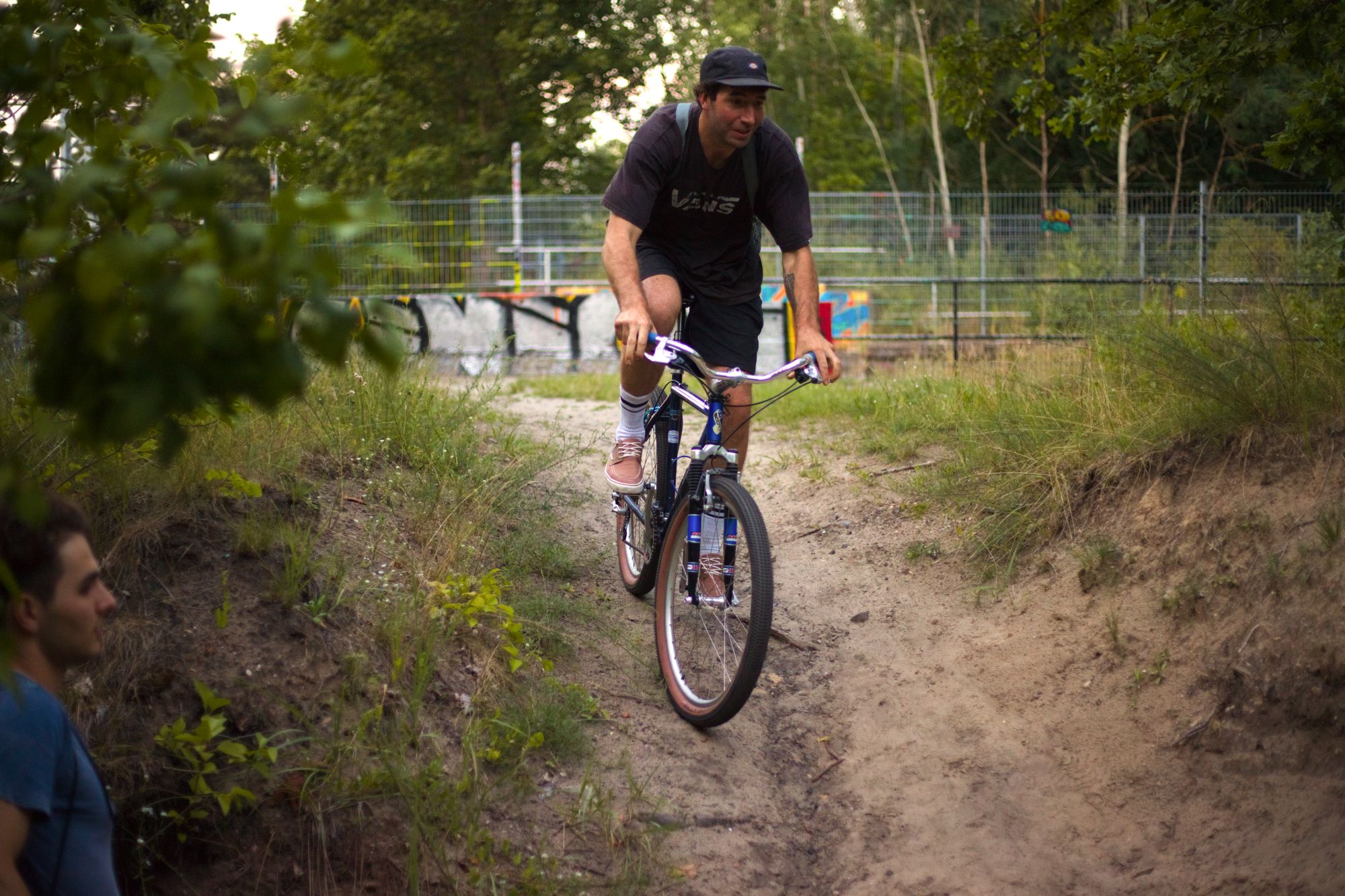 Rider descending a sandy trail on a blue mountain bike