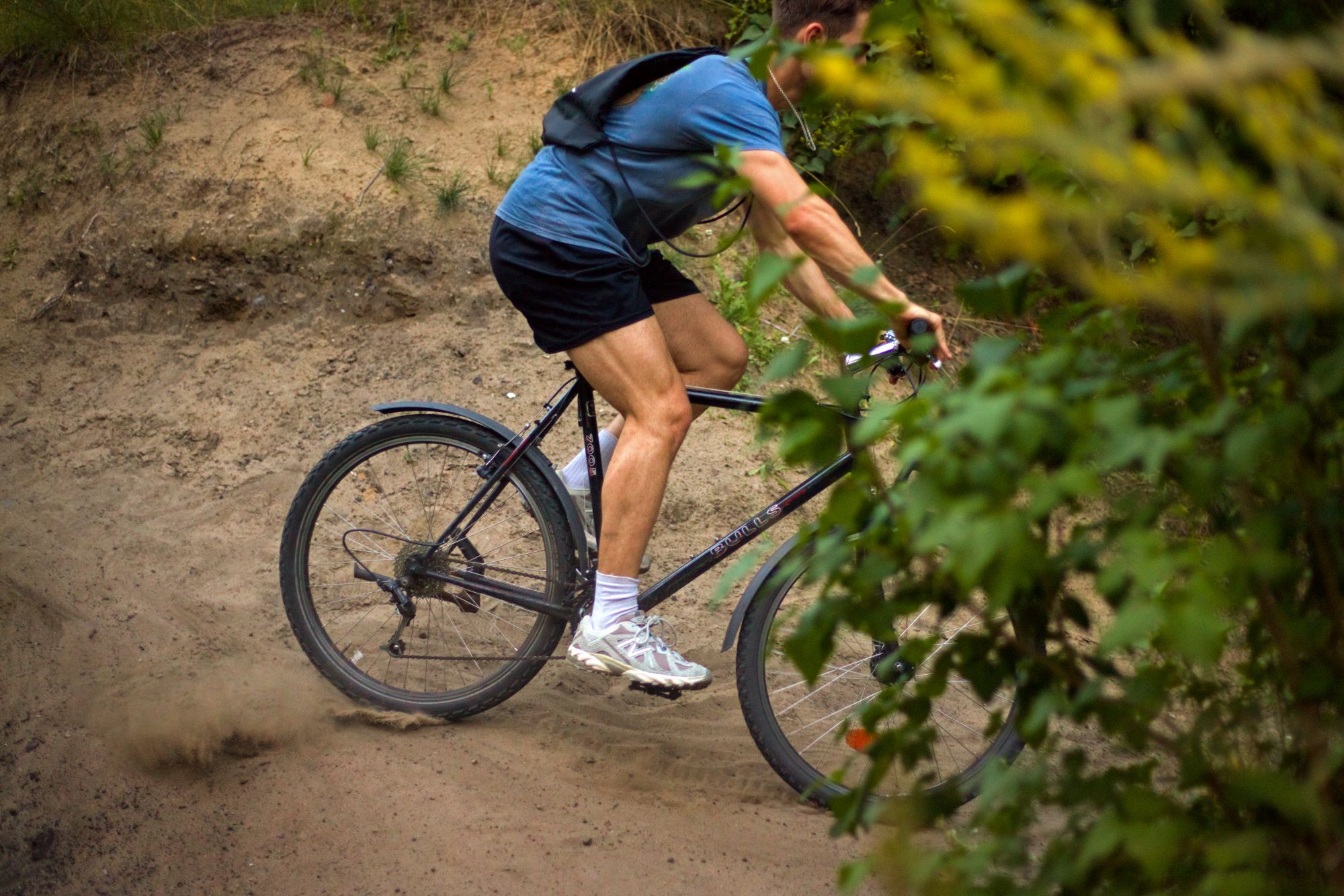 Rider on a classic mountain bike passing behind leaves